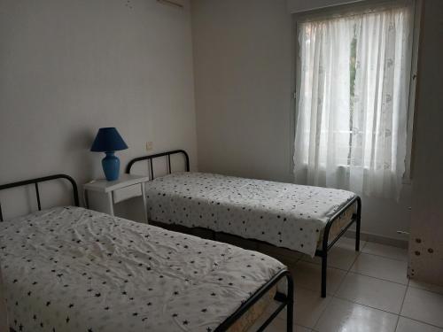 1 dormitorio con 2 camas y ventana en Superbe appartement dans résidence avec piscine en Saint-Aygulf