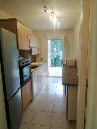 Il comprend une cuisine équipée d'un évier et d'un réfrigérateur. dans l'établissement Superbe appartement dans résidence avec piscine, à Saint-Aygulf
