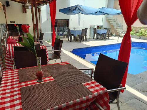 a table and chairs next to a swimming pool at HBCF Hotel Boutique Casa Farallones de Santiago de Cali in Cali