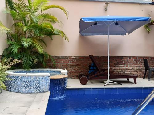 an umbrella and a chair next to a swimming pool at HBCF Hotel Boutique Casa Farallones de Santiago de Cali in Cali