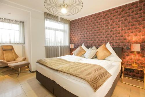 a bedroom with a large bed and a chair at FeWo Konstanze in Borkum