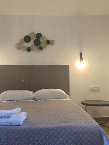 ein Schlafzimmer mit einem Bett und einer Uhr an der Wand in der Unterkunft Ocean Sun 4 in Fira