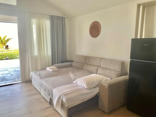 a bedroom with a bed and a couch and a refrigerator at Ocean Sun 4 in Fira