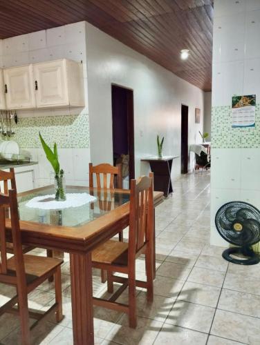 uma cozinha e sala de jantar com mesa e cadeiras em 7 camas de casal - Casa próxima ao Bumbódromo em Parintins