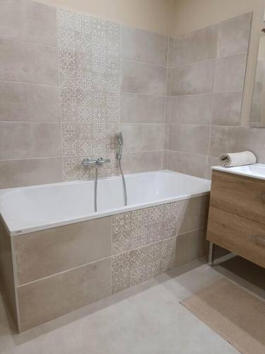 une salle de bain avec une baignoire et un lavabo dans l'établissement Maison au cœur du village avec parking, à Étretat
