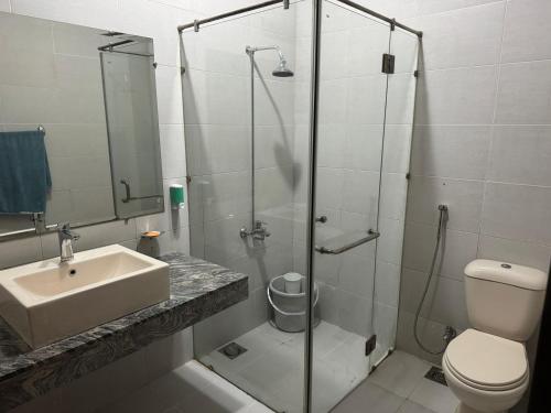 La salle de bains est pourvue d'une douche, d'un lavabo et de toilettes. dans l'établissement Holidazzle Villa, à Karachi