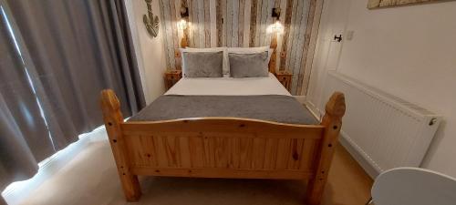 een kleine slaapkamer met een houten bed in een kamer bij Trentham House in Paignton