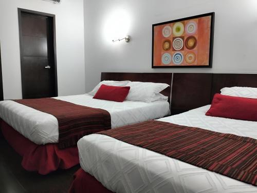 two beds sitting next to each other in a room at HBCF Hotel Boutique Casa Farallones de Santiago de Cali in Cali