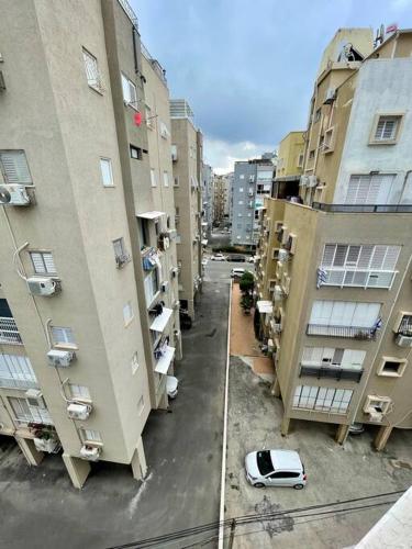 a city street with buildings and a car parked between them at Bat Yam Penthouse Sea View in Bat Yam