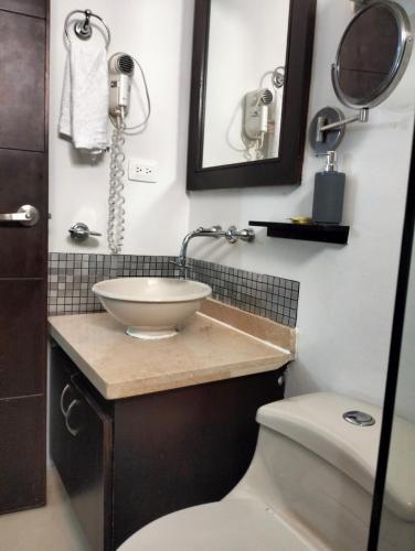 a bathroom with a sink and a toilet and a mirror at HBCF Hotel Boutique Casa Farallones de Santiago de Cali in Cali