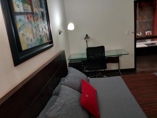 a bedroom with a bed with a red pillow on it at HBCF Hotel Boutique Casa Farallones de Santiago de Cali in Cali