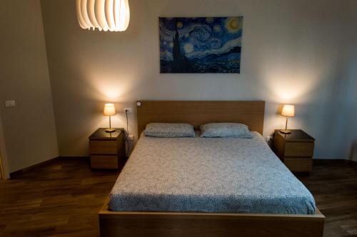 ein Schlafzimmer mit einem Bett mit zwei Nachttischen und zwei Lampen in der Unterkunft Bed&Breakfast Bella Vita in Bracco