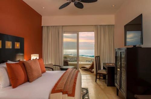een slaapkamer met een groot bed en een groot raam bij Sunset Beach golf & spa Resort Pueblo Bonito in Cabo San Lucas