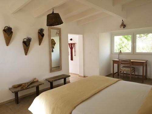 a bedroom with a bed and a mirror and a table at Formentera Mind Yoga & Fit in Playa Migjorn
