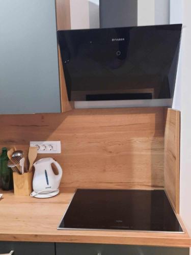 a kitchen counter with a microwave and a laptop at Apartments Blažič in Kranjska Gora