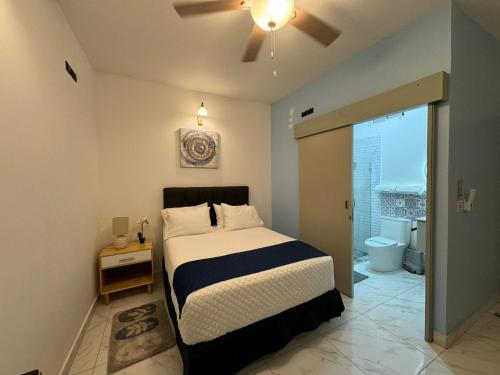 a bedroom with a bed and a ceiling fan at Apartaestudios La capital in San José