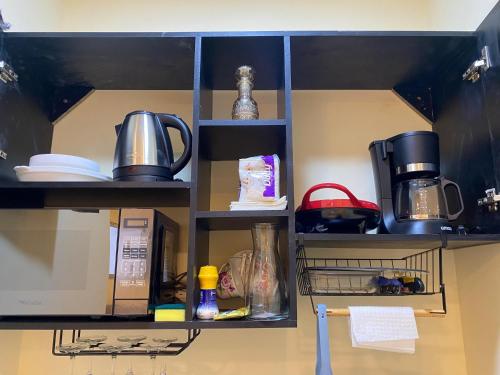 a kitchen shelf with a microwave and a coffee maker at Microsuite 2 hermosa y céntrica in Guayaquil