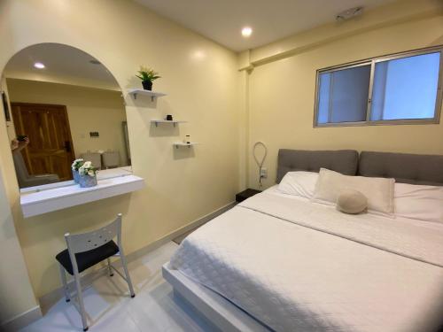 um quarto com uma cama, um espelho e uma cadeira em Microsuite 2 en Guayaquil elegante y privada em Guayaquil