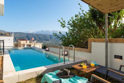 a swimming pool with a table and a picnic table next to a house at SeaviewHeaven - Private pool - Overlooking Chania in Chania Town