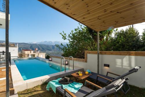 a swimming pool with a patio furniture and a wooden pergola at SeaviewHeaven - Private pool - Overlooking Chania in Chania Town