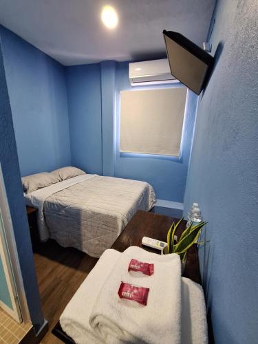 a blue room with two beds and a table with towels at LA CASA AZUL DE SAMARA in Barrio Nuevo