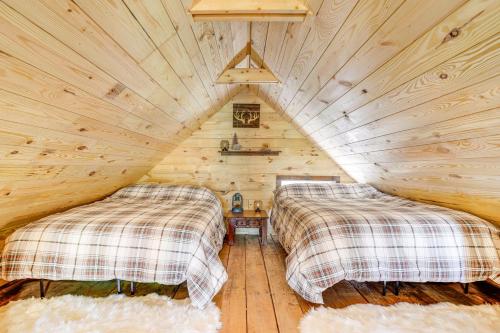 Lake ToxawayにあるSecluded Brevard Cabin with Private Waterfall!の丸太小屋のベッドが2つある寝室