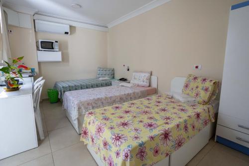 ein kleines Schlafzimmer mit 2 Betten und einem Sofa in der Unterkunft Flat Econômico in São Paulo
