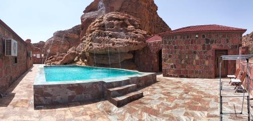 une piscine au milieu d'une montagne dans l'établissement Red Mountain Farm, à Al-Ula