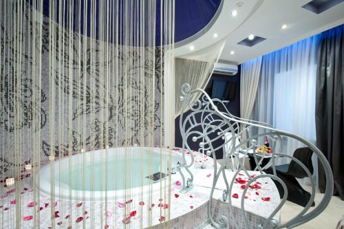 a room with a glass table and a bed with flowers at Style Hotel in Kharkiv