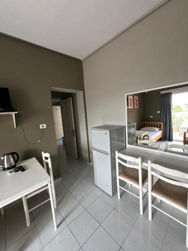 a kitchen with a table and a table and chairs at Olivias Apartments City Center in Sarandë