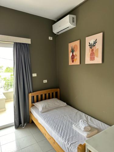 a small bedroom with a bed and a window at Olivias Apartments City Center in Sarandë