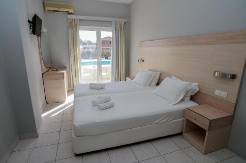 モライティカにあるAlexandros Studios Moraitikaのベッドルーム1室(白いシーツ付きのベッド1台、窓付)