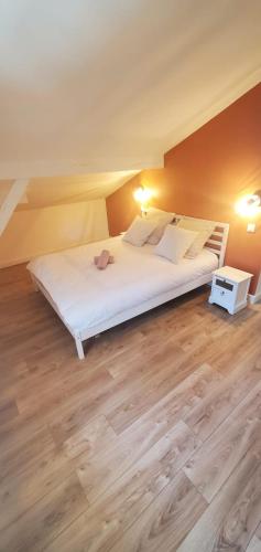 une chambre avec un grand lit blanc et un parquet dans l'établissement Magnifique Villa proche Golf & Centre d' Hossegor avec Jacuzzi, à Capbreton