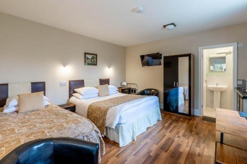 a hotel room with two beds and a bathroom at Roger Ground Guest House - with Onsite Car Parking in Windermere