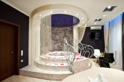 Zimmer mit einem Stuhl und einem Zimmer mit einer Wand in der Unterkunft Style Hotel in Kharkov