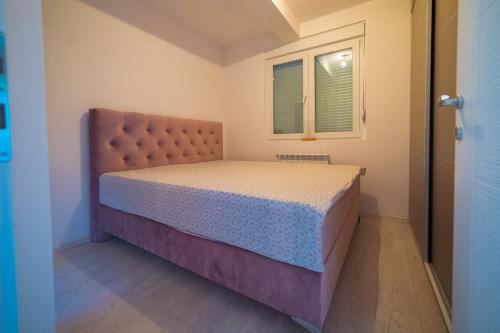 - une petite chambre avec un lit et une fenêtre dans l'établissement Apartman BOJANA, à Pirot