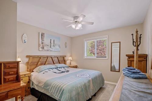 sypialnia z łóżkiem i wentylatorem sufitowym w obiekcie Grandview Beach Retreat - an incredible beachfront is waiting for you w mieście Port McNicoll