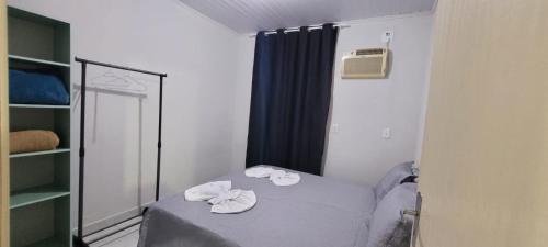 um pequeno quarto com uma cama e um espelho em Casa ao lado da Dubai brasileira em Camboriú