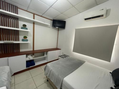 um quarto com uma cama e um quadro negro na parede em Cozy Cabin in Santa Tecla, 25 mins from surf city em Nueva San Salvador