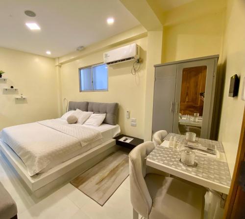 Un dormitorio con una cama y una mesa. en Microsuite 1 hermosa y privada, en Guayaquil