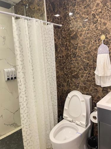 a bathroom with a toilet and a shower curtain at Condo Arcadia Beach jomtien pattaya in Pattaya South