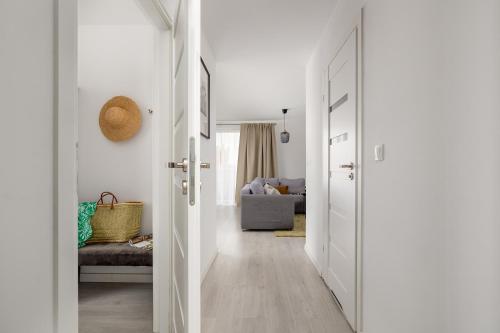 a hallway with white doors and a living room at TS Hello City Apartment in Szczecin