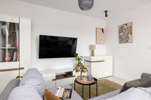 a living room with a couch and a flat screen tv at TS Hello City Apartment in Szczecin