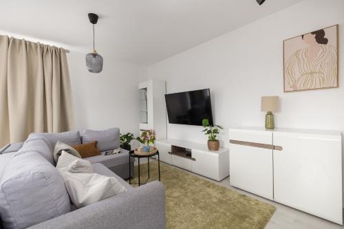 a living room with a couch and a flat screen tv at TS Hello City Apartment in Szczecin