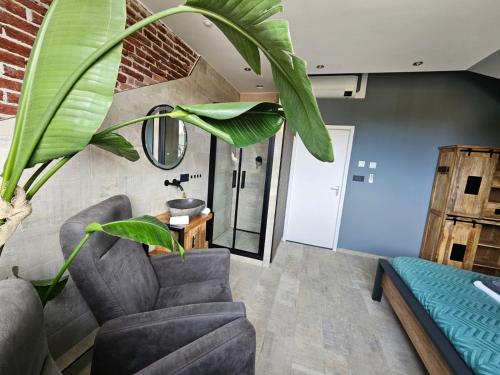 a living room with a couch and a plant at Gezond aan Zee, Zeeschelp, wellnesstuin tegen meerprijs in Ouddorp