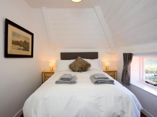 um quarto com uma cama branca com duas toalhas em 6 Bed in Wroxham 72652 em Hoveton