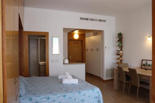a room with a bed and a table and a kitchen at Beautiful lake in Garda