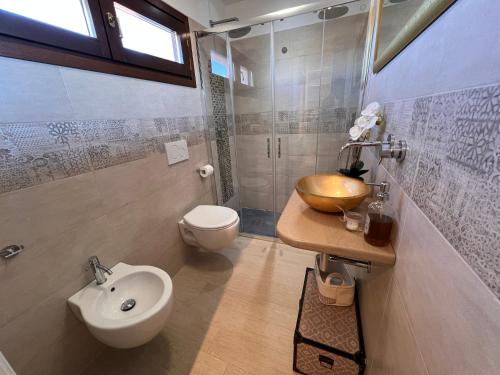 a bathroom with a sink and a toilet and a sink at Villetta panoramica con giardino in Ossi