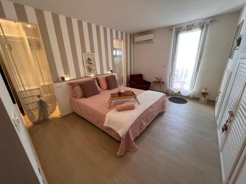 a bedroom with a bed and a striped wall at Villetta panoramica con giardino in Ossi