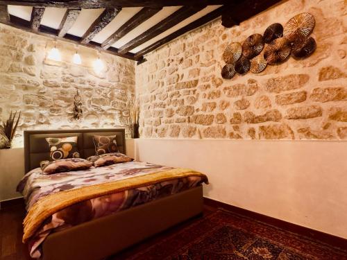 a bedroom with a bed in a stone wall at Luxury studio design by KENZO with Jacuzzi in Paris